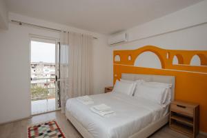 een slaapkamer met een wit bed en een groot raam bij Erik's Place in Shkodër