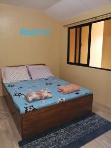 een slaapkamer met een bed met een kamerbord erop bij Triple JS Home Deca Clark Residences in Angeles