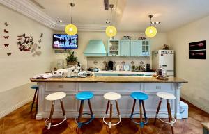 a kitchen with blue stools at a kitchen island at 七星天使-七星潭電梯民宿 in Dahan