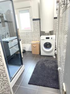 uma casa de banho com uma máquina de lavar roupa e uma máquina de lavar roupa. em Maison de 2 chambres avec wifi a Andres em Andres