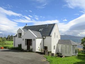 a white house with a view of the water at Macinnisfree Cottage in Saasaig
