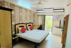 a bedroom with a bed with red pillows at Hotel Kanak Sagar in Ajmer