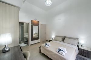 1 dormitorio con 1 cama grande y toallas. en Byron Rooms, en La Spezia