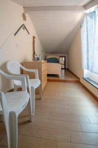 Zimmer mit einem Bett, 2 Stühlen und einem Tisch in der Unterkunft Terrazza cielo e mare in Imperia