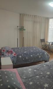 1 dormitorio con 2 camas, mesa y ventana en Casa 1er piso D&C, en Huancayo