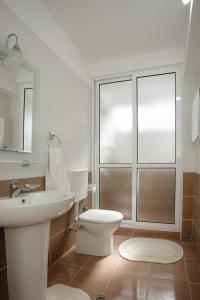 een badkamer met een wastafel, een toilet en een raam bij Erik's Place in Shkodër