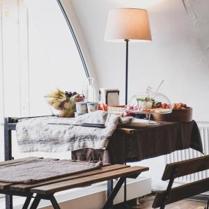 una mesa con un mantel con una lámpara en Rooms and Suites at Bookinn B&B en Vilna
