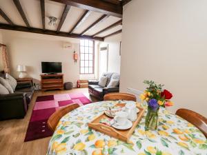 un soggiorno con tavolo e vaso di fiori di The Woodman a Llandrindod Wells