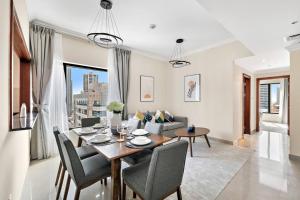 a dining room and living room with a table and chairs at StoneTree - Time Place Tower 1 BR - Amazing View in Dubai