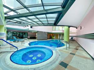a large swimming pool in a large building at StoneTree - Time Place Tower 1 BR - Amazing View in Dubai