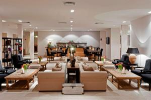 a lobby with couches and tables and a bar at Tryp by Wyndham Wuppertal in Wuppertal