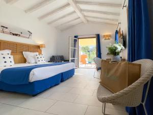 um quarto de hotel com uma cama e uma cadeira em Le Mouillage em Saint-Tropez