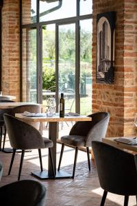 a dining room with tables and chairs and windows at Mormoraia in San Gimignano