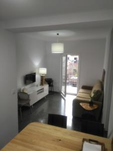 ein Wohnzimmer mit einem Sofa und einem TV in der Unterkunft Sevilla Macarena apartamento 3 dormitorios in Sevilla