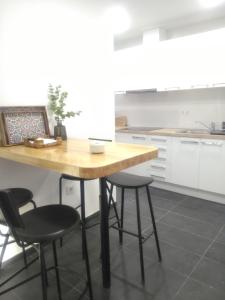 eine Küche mit einem Holztisch und 4 Stühlen in der Unterkunft Sevilla Macarena apartamento 3 dormitorios in Sevilla