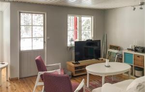 sala de estar con TV, mesa y sillas en Gorgeous Home In Herrng With Kitchen en Herräng
