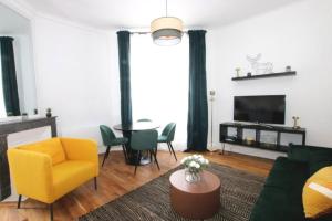 a living room with a yellow chair and a table at L'Atelier Gallé - Parc Ste Marie - Nancy Thermal in Nancy