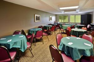 une salle de conférence avec des tables vertes et des chaises rouges dans l'établissement AmericInn by Wyndham Beaver Dam, à Beaver Dam