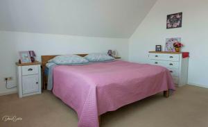 ein Schlafzimmer mit einem rosa Bett und zwei Nachttischen in der Unterkunft Große Unterkunft zum Wohlfühlen in Stelle