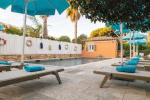 a swimming pool with blue lounge chairs and umbrellas at Le Mouillage in Saint-Tropez