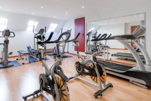 - une salle de sport avec des vélos de cardio-training et des tapis roulants dans l'établissement AC Hotel León San Antonio by Marriott, à León