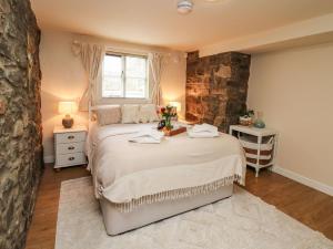 um quarto com uma cama grande e uma parede de pedra em The Middleton em Llandrindod Wells