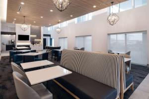 a dining room with tables and chairs and lights at La Quinta by Wyndham Chicago O'Hare Airport in Rosemont