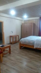 een slaapkamer met een bed en een houten kast bij Heavess Peak Hotel in Muzaffarabad +6 foto's