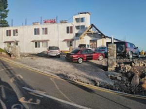 een groep auto's geparkeerd voor een gebouw bij Heavess Peak Hotel in Muzaffarabad