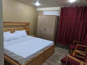 een slaapkamer met een bed en een rood gordijn bij Heavess Peak Hotel in Muzaffarabad