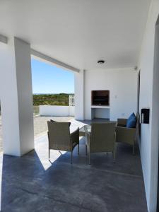 Un comedor con mesa y sillas y el océano. en Villa Maria, en Dwarskersbos