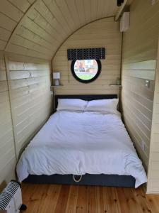 a bed in a small room with a window at Spring Tide Cliff Top Glamping Pod with direct Sea Views in Birchington
