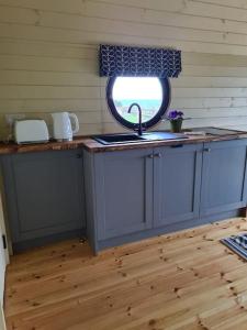 a kitchen with a sink and a window at Spring Tide Cliff Top Glamping Pod with direct Sea Views in Birchington