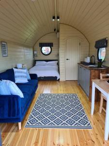 a bedroom with a bed and a blue couch at Spring Tide Cliff Top Glamping Pod with direct Sea Views in Birchington