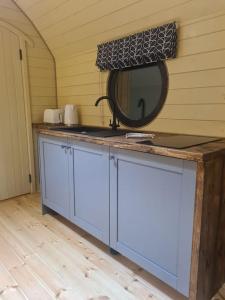 a bathroom with a sink and a mirror on the wall at Spring Tide Cliff Top Glamping Pod with direct Sea Views in Birchington