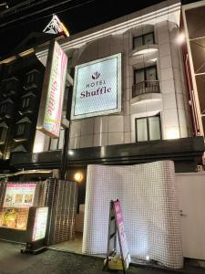 un edificio con un cartel que lee el transbordador del motel en HOTEL Shuffle, en Tokio