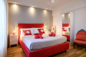 a bedroom with a large bed with red pillows at Lady Camollia Apartment in Siena