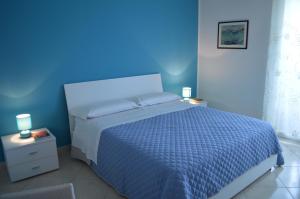 niebieska sypialnia z łóżkiem i niebieską ścianą w obiekcie B&B Le Tre Stelle w mieście Milazzo