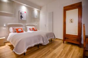 ein Schlafzimmer mit einem Bett mit orangefarbenen Kissen darauf in der Unterkunft Lady Camollia Apartment in Siena