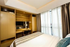 a hotel room with a bed and a desk and a window at Guangzhou Laixizhou Pazhou Aparthotel - Enjoy free Shuttle Bus & Guidance Service in Canton Fair in Guangzhou