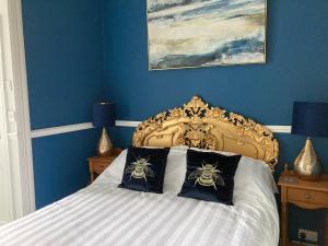 a bedroom with a bed with blue walls at Paragon Home in Ramsgate