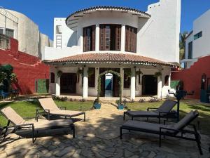 een huis met een patio met stoelen ervoor bij VILLA OASIS in Puerto Vallarta