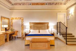 a bedroom with a bed and a desk and a staircase at Villa Tolomei Hotel & Resort in Florence