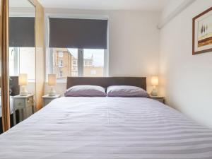 馬蓋特的住宿－Sherwood Apartment，一间卧室配有一张带两盏灯的大型白色床。