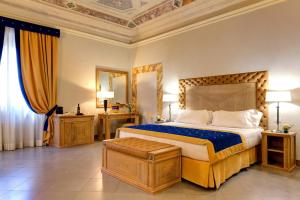 Villa Tolomei Hotel & Resort في فلورنسا: غرفة نوم مع سرير مزدوج كبير في غرفة