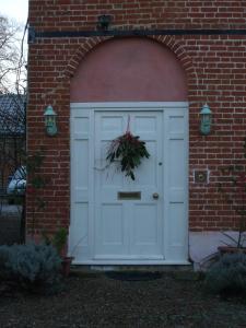 a white garage door with a wreath on it at The Old Vicarage Bed And Breakfast in Hindolveston