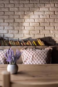 a brick wall with pillows and a table with purple flowers at Casa Meburger 279 