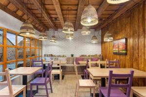 a restaurant with wooden tables and purple chairs at Casa Meburger 279 