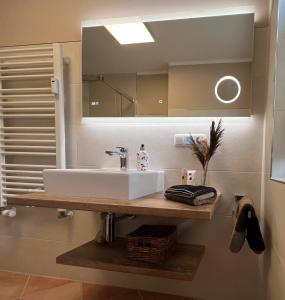 een badkamer met een witte wastafel en een spiegel bij Ferienwohnung Baumann in Prerow