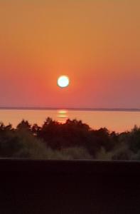 un tramonto sull'oceano con il sole nel cielo di Domek na Tęczowym Wzgórzu a Suchacz